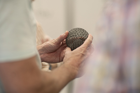 student showcasing 3d printed sphere